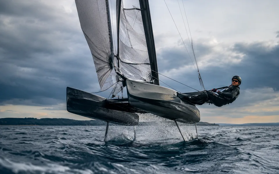 Foiling catamaran lifted clear of the water on its hydrofoils